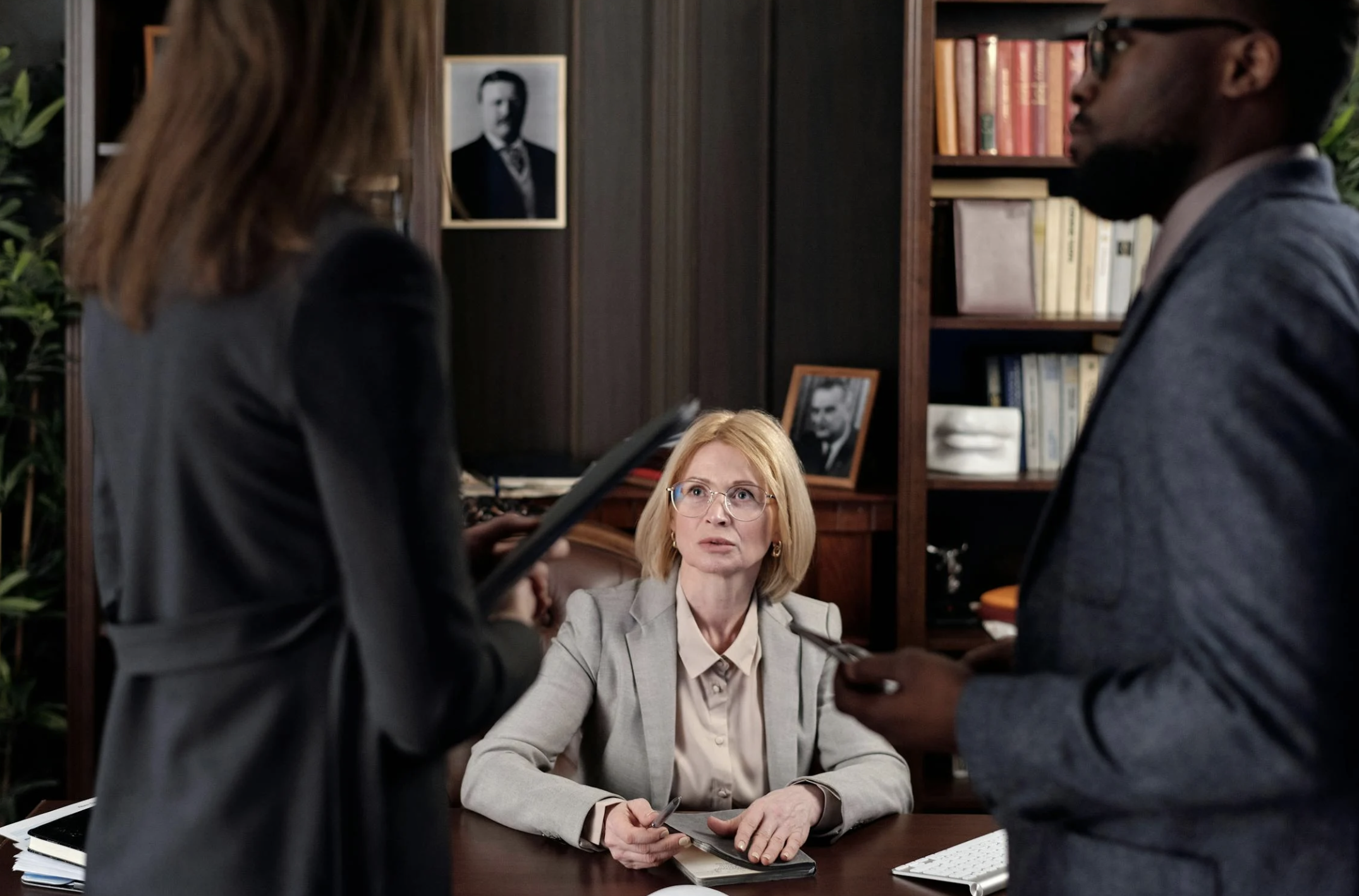 2 Employees Standing in Front of Female Employment Attorney